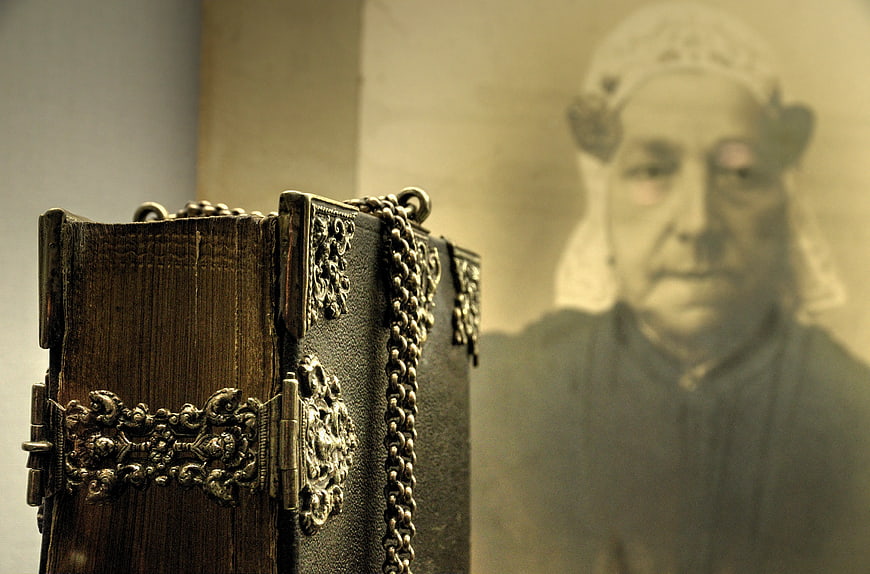 Antique leather book with silver clasps and blurred portrait background