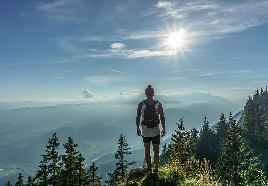 Woman Hiking on Mountain Peak Overlooking Valley
