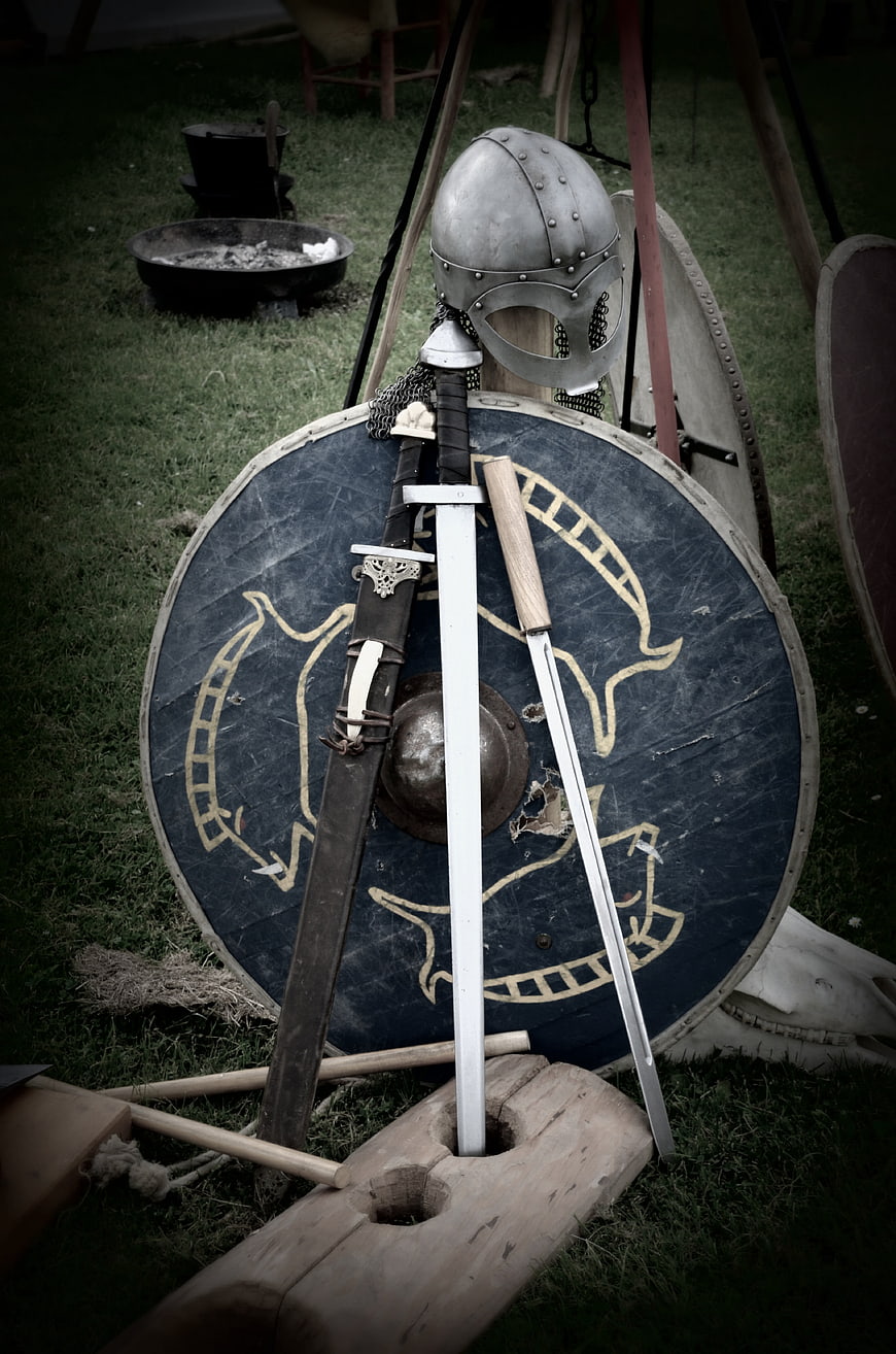 Medieval Viking Shield, Helmet, and Swords on Grass