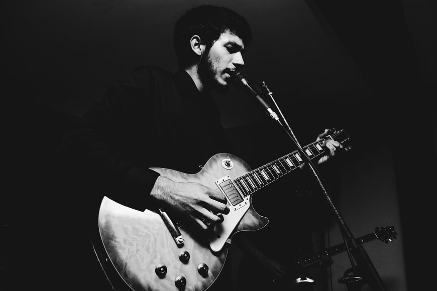 Male Musician Playing Electric Guitar on Stage