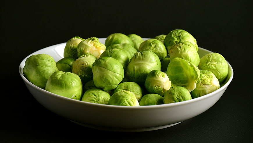 Fresh Brussels Sprouts In White Bowl On Black Background