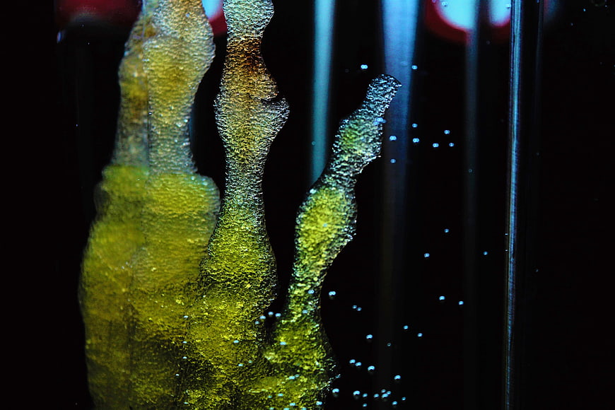 Abstract Bio-Art Sculpture with Glowing Yellow Texture and Blue Bubbles