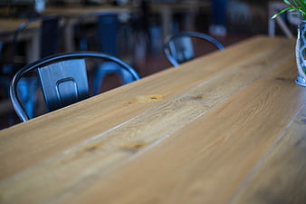 Empty wooden table in a modern cafe with chairs