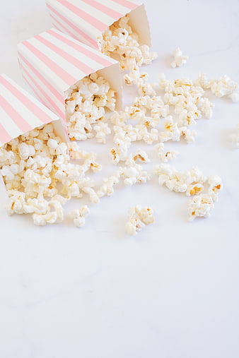 Pink striped popcorn boxes spilling onto white marble surface
