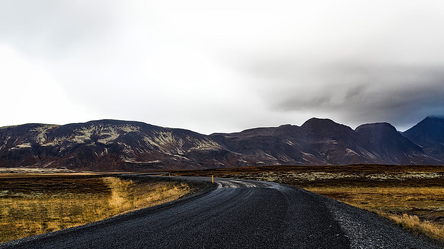 Winding Gravel Road Through Icelandic Landscape with Mountains