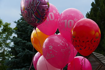 Pink and red 10th birthday balloon bouquet outdoors