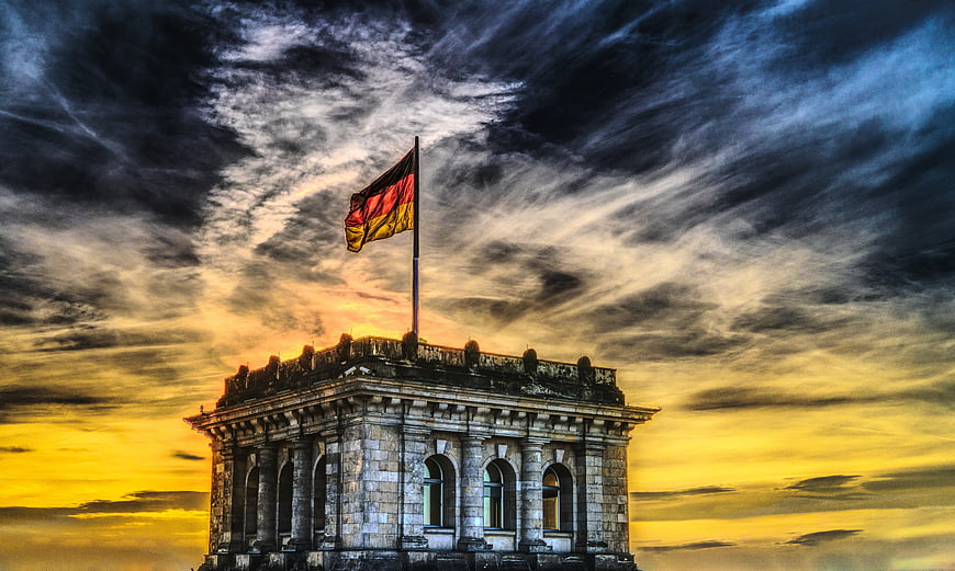 German Flag on Reichstag Building Against Dramatic Sunset Sky