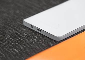 Close-up of white smartphone bottom edge on textured surface
