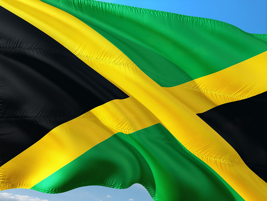 Waving Jamaican Flag Against Blue Sky