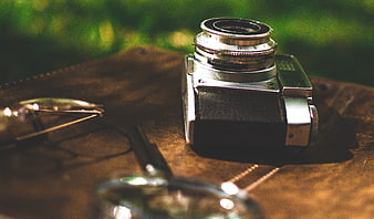 Vintage Camera and Glasses on Leather Surface