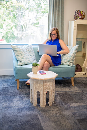 Woman working on laptop in bright living room