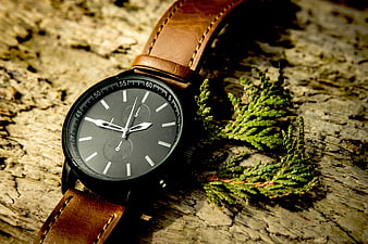 Black Chronograph Watch with Brown Leather Strap on Wood