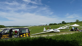 Gliders on grassy airfield with blue sky