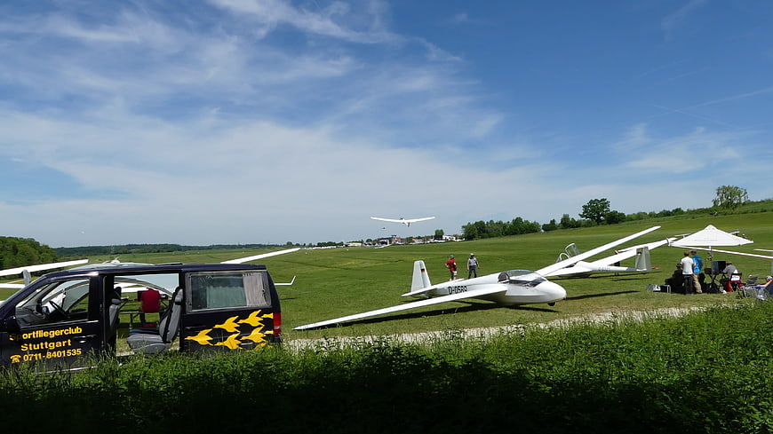 Gliders on grassy airfield with blue sky