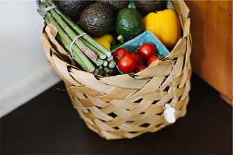 Woven basket filled with fresh organic vegetables and produce