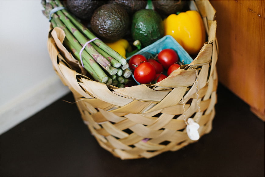 Woven basket filled with fresh organic vegetables and produce
