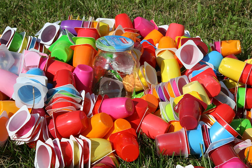 Pile of colorful plastic yogurt cups on grass