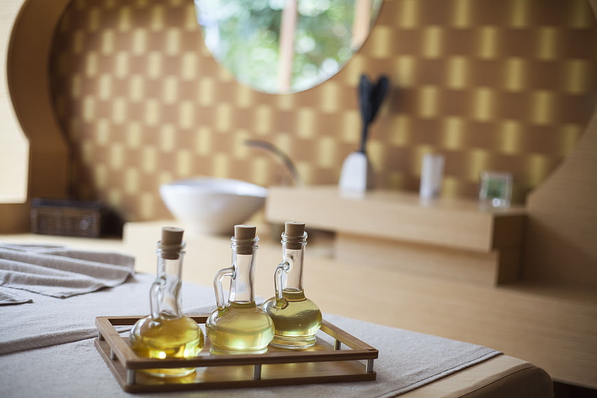 Spa massage oils on wooden tray in serene wellness room