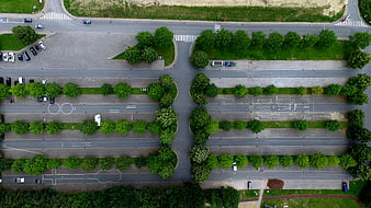 Aerial View of Urban Intersection with Green Trees and Roads