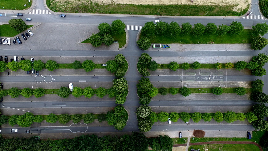 Aerial View of Urban Intersection with Green Trees and Roads