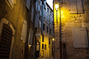 Narrow European Street at Night with Warm Street Lamp
