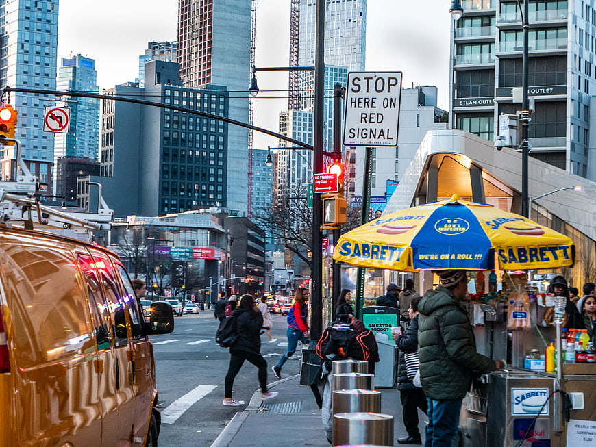 Busy Brooklyn Street Scene with Yellow Taxi and Hot Dog Stand