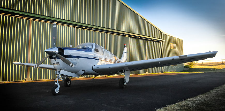 Small Private Propeller Airplane Parked In Front Of Hangar
