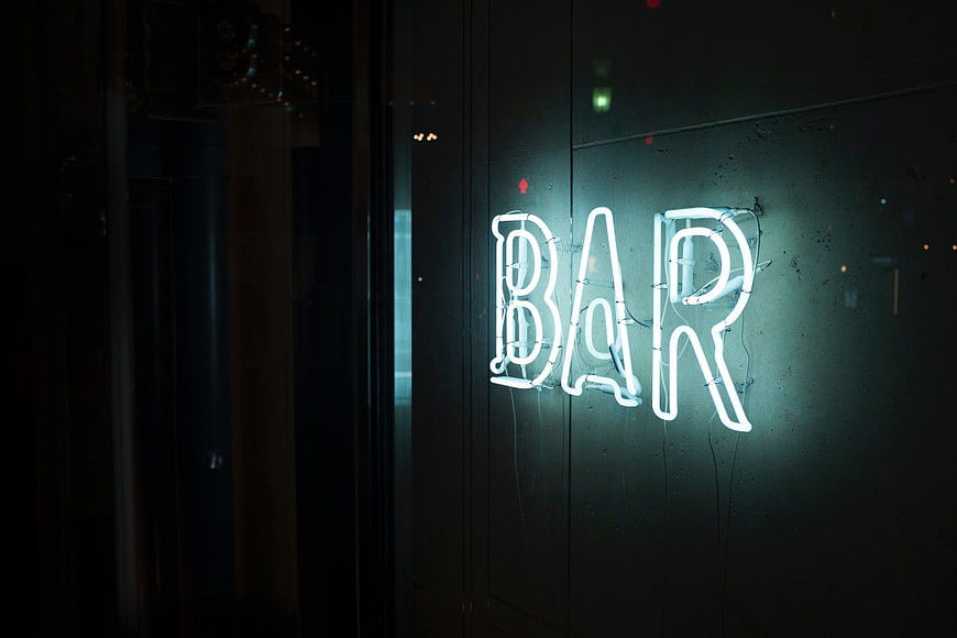 Glowing Neon Bar Sign on Dark Wall