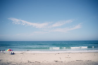 Wide Beach Landscape with Blue Sky and Colorful Umbrella