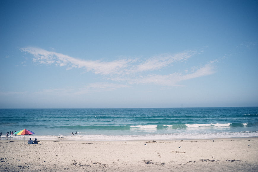 Wide Beach Landscape with Blue Sky and Colorful Umbrella