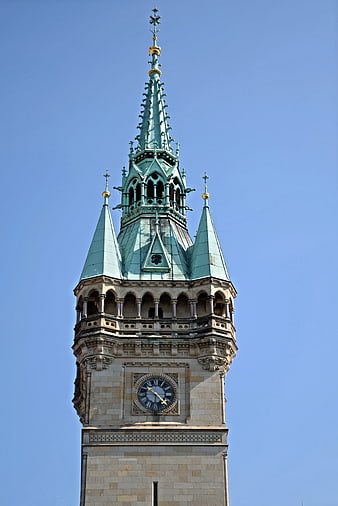 Low angle view of ornate church tower spire against blue sky