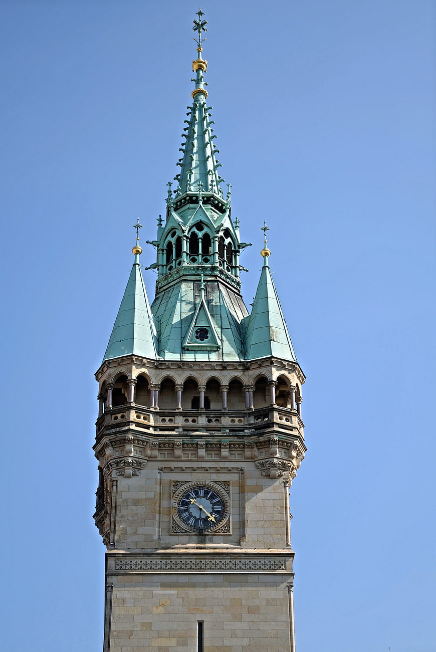 Low angle view of ornate church tower spire against blue sky