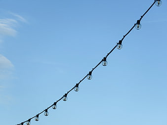 String of light bulbs against a clear blue sky