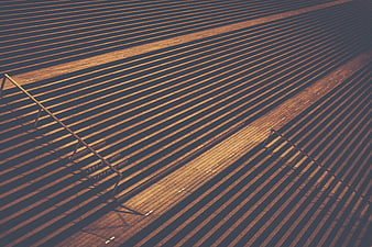 Abstract geometric pattern of empty stadium bleachers with long shadows