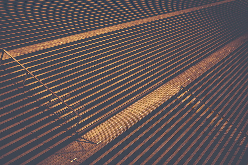 Abstract geometric pattern of empty stadium bleachers with long shadows