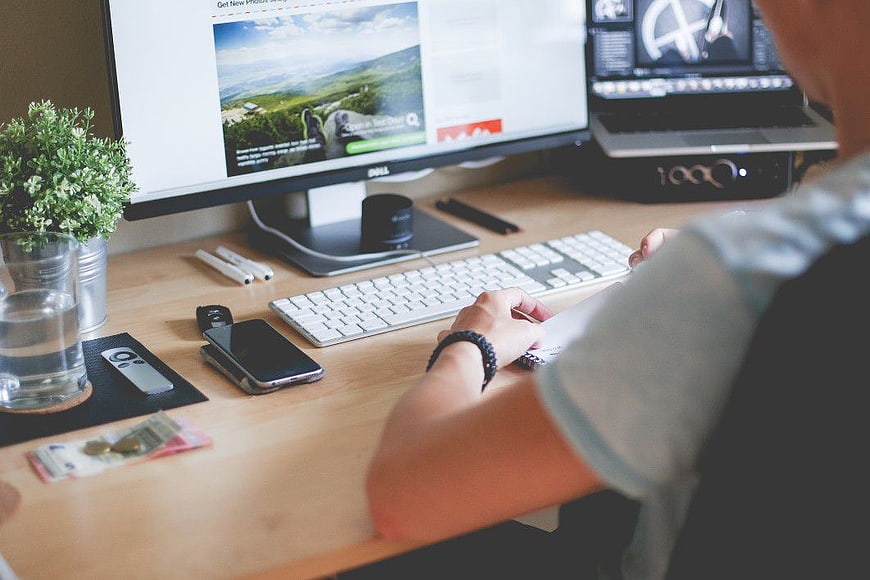 Man working at desk with computer and smartphone