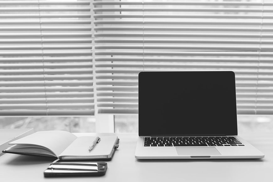 Minimalist Black and White Office Desk with Laptop and Notebook