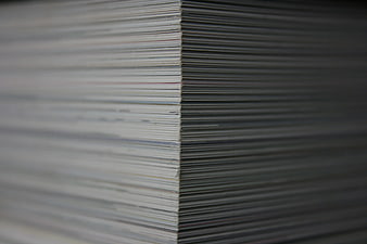 Close-up of stacked paper sheets in a gray office setting