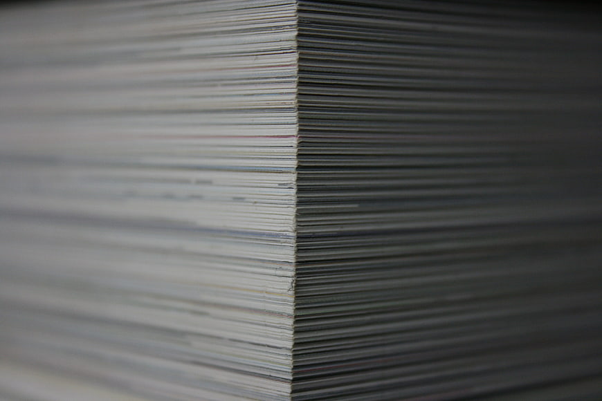 Close-up of stacked paper sheets in a gray office setting