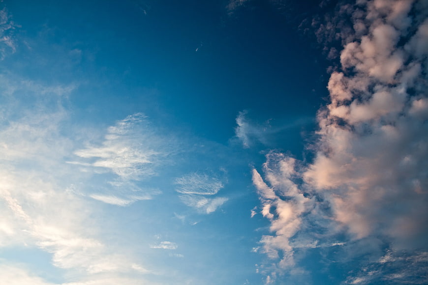 Blue sky with fluffy white clouds and soft sunlight