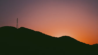 Silhouette of Mountain Ridge with Power Lines at Sunset