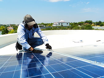 Technician Installing Solar Panels On Residential Rooftop