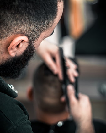 Barber Cutting Hair with Clippers and Comb