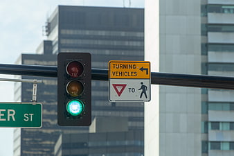 Green Traffic Light and Yield Sign in Urban Cityscape