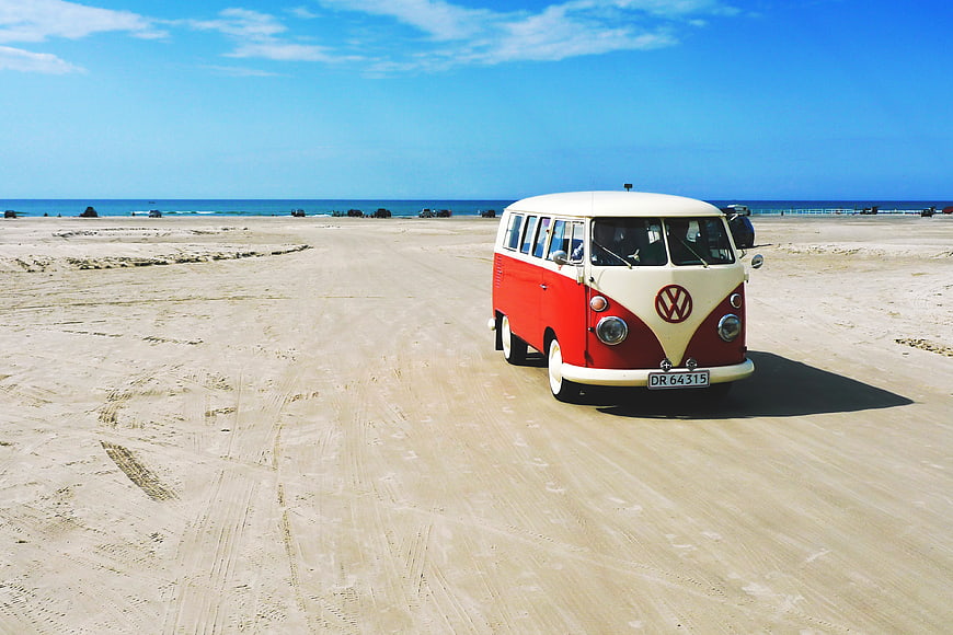 Vintage Red and White VW Camper Van on Sandy Beach