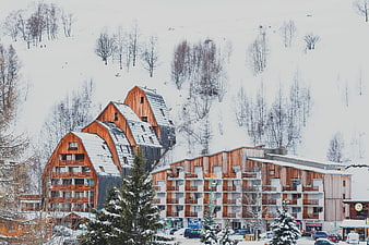 Modern wooden ski resort buildings on snowy mountain slope