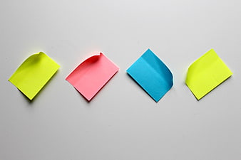 Four colorful sticky notes arranged in a row on a white background