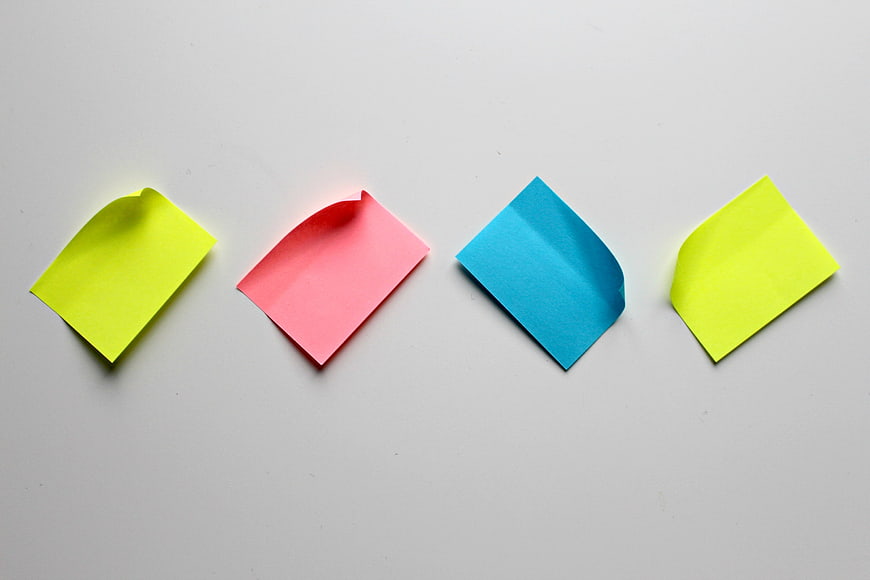 Four colorful sticky notes arranged in a row on a white background