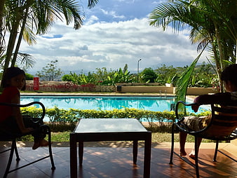 Relaxing View of Tropical Swimming Pool From Shaded Patio