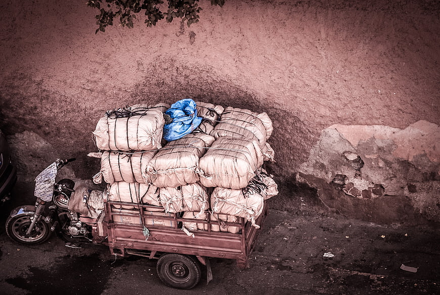 Motorcycle loaded with large sacks against a textured wall